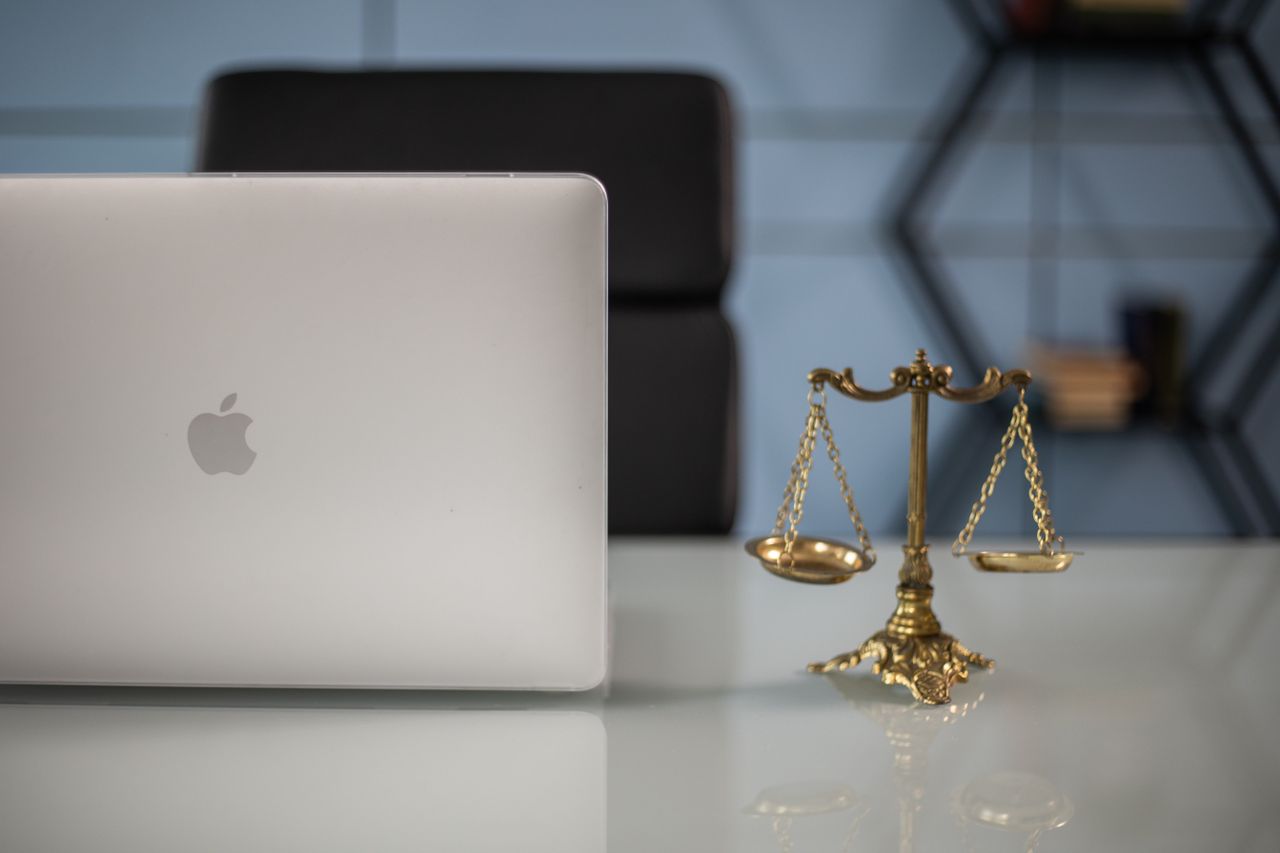 Home Elegant balance of technology and justice scales on an office desk.