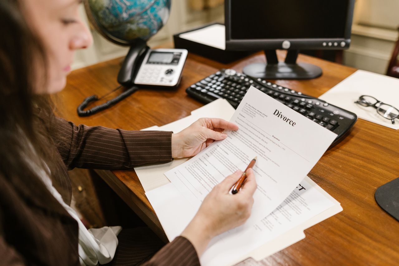 Home A lawyer examines divorce documents at a desk in a law office setting, emphasizing professionalism.